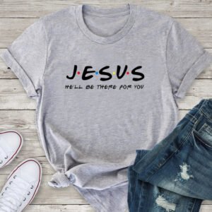 Gray T-shirt laid flat featuring the word 'JESUS' with colorful dots between letters and the slogan 'He'll be there for you' beneath it.