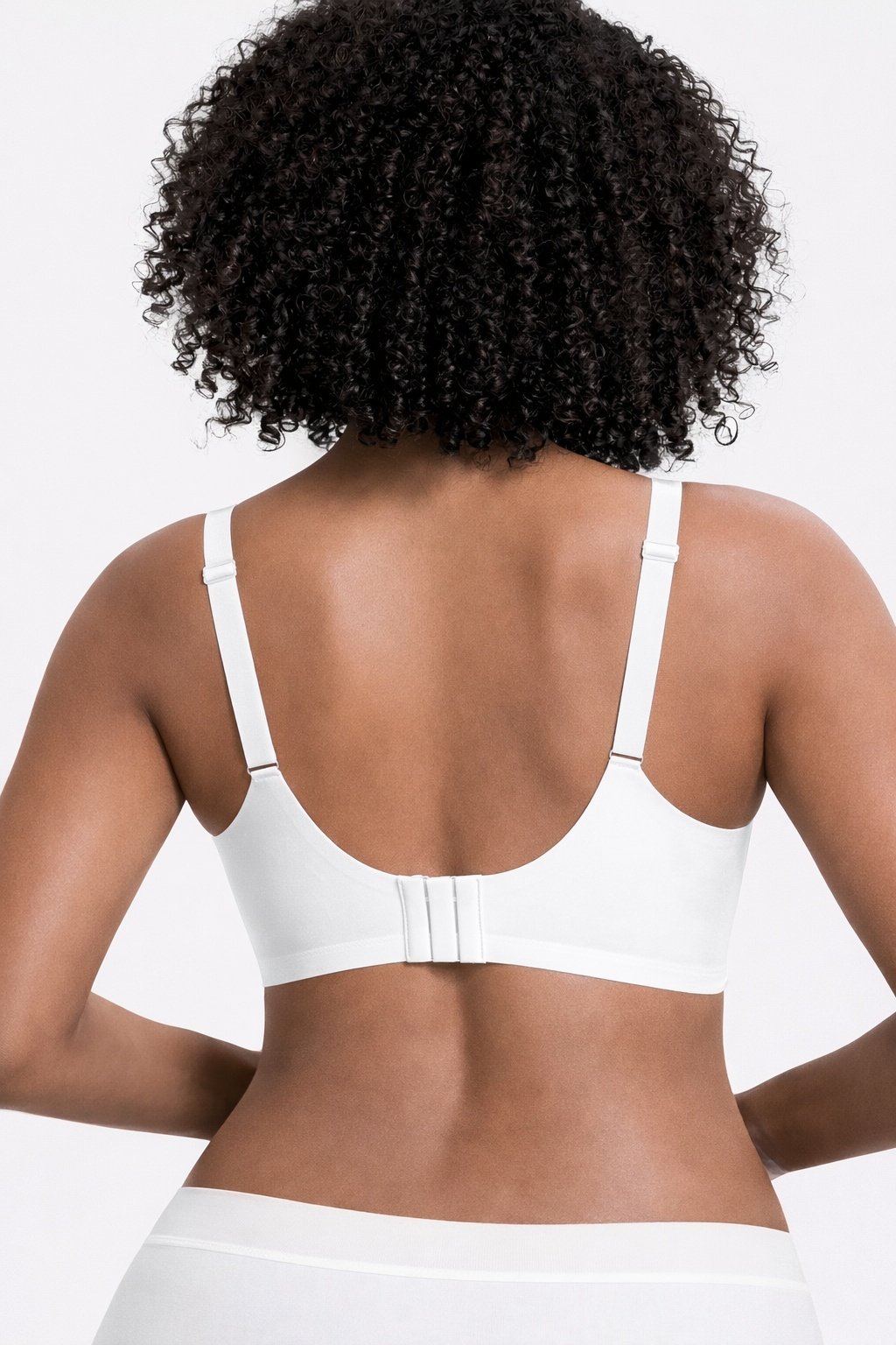235122ea-4996-4231-9a8f-8d52687647e8jpg • Punkin's Patch Back view of a person with curly hair wearing a white bra with adjustable straps and a three-hook closure.