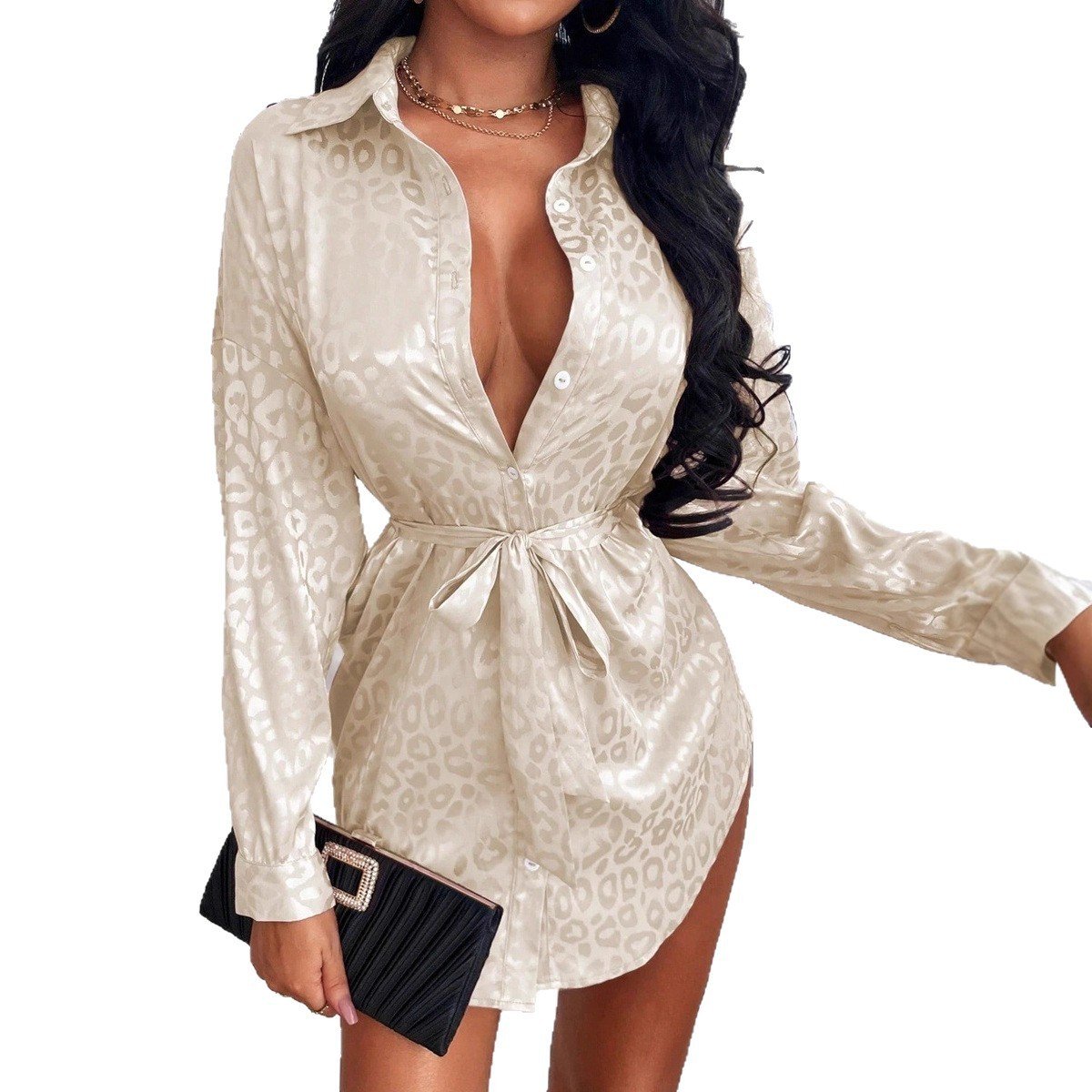 7320cbc1-5036-498b-b46b-0787ecdebab7jpg • Punkin's Patch Woman in a beige satin leopard-print shirt dress with a waist tie, deep V-neck, and long sleeves, holding a black clutch with a jeweled buckle.