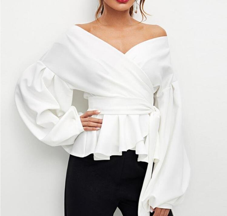 7ba78912-ff15-49fb-9c54-eb7a140f752fjpg • Punkin's Patch Woman in a white off-shoulder peplum blouse with large puff sleeves and a tied waist, paired with black pants.