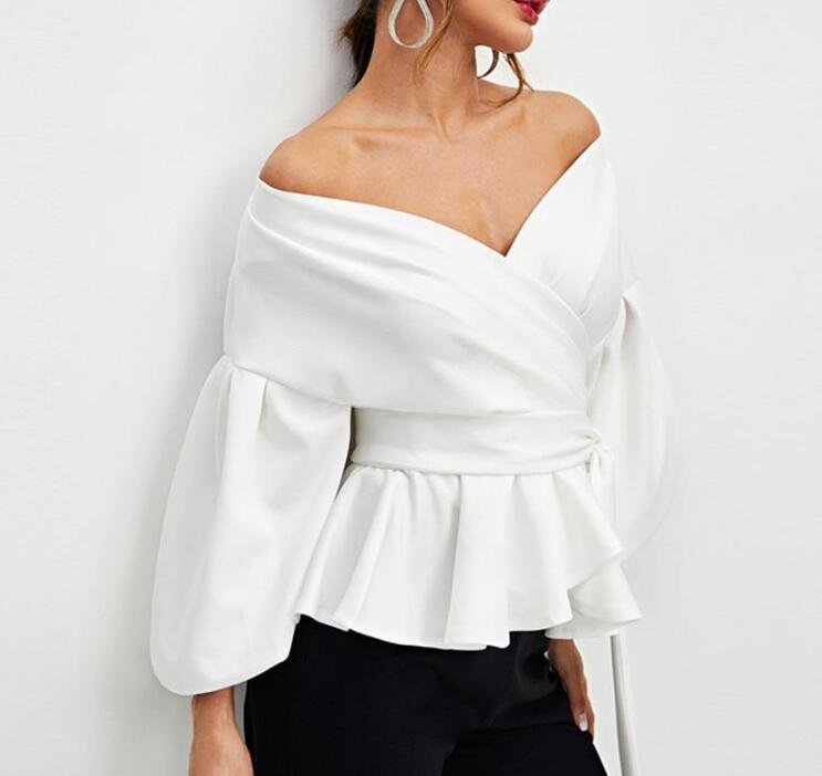 8553b5ad-6e81-44f1-b206-1e35ea028b63jpg • Punkin's Patch White off-shoulder wrap blouse with a peplum waist and voluminous sleeves on a model, paired with black pants