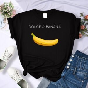 Flat-lay black tee with a banana graphic and 'DOLCE & BANANA' text, surrounded by denim and sneakers.