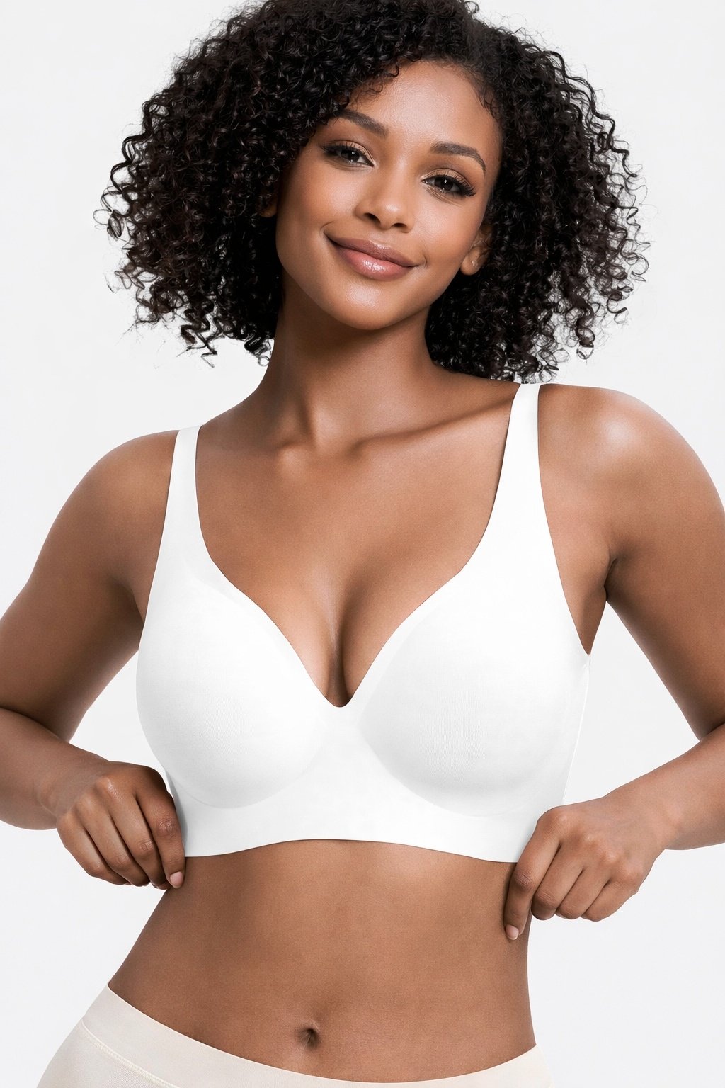 cb2f80e4-c016-41c2-a8aa-19d54d30af0cjpg • Punkin's Patch Smiling woman with curly hair wearing a white bra against a light background.