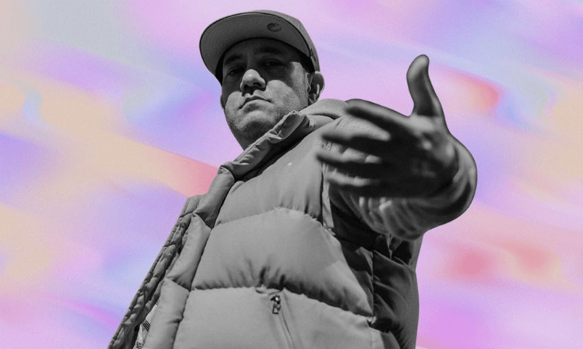 Man wearing a cap and puffy jacket extends his hand toward the camera against a pastel, abstract background.