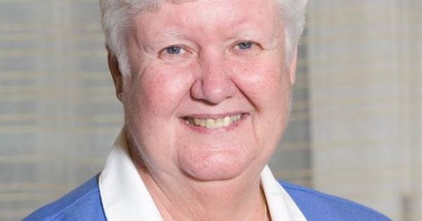 wp-header-logo-912png • Punkin's Patch Smiling elderly woman with short white hair wearing a blue blazer and white blouse, indoors against a neutral background.